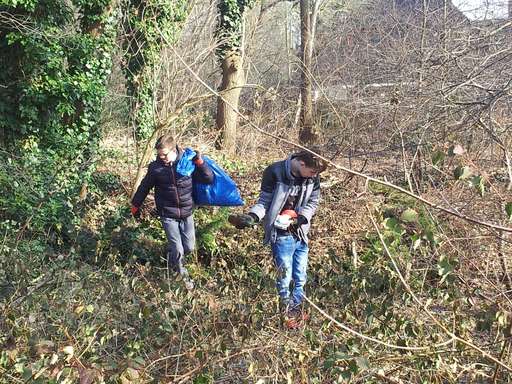Zwei Kinder im Wald beim Müllsammeln