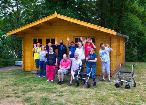 Das Bild zeigt Bewohnerinnen und Bewohner vor dem neuen Gartenhaus