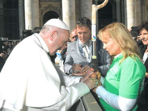 Papst Franziskus legt Hände um den Pilgerstab und Astrid Schmidts Hände