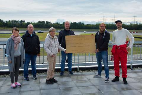 Auf dem Bild übergeben die beiden Veranstalter der Oldtimer Trackdays einen Spendenscheck an Vertreter von pro Vitus e.V.
